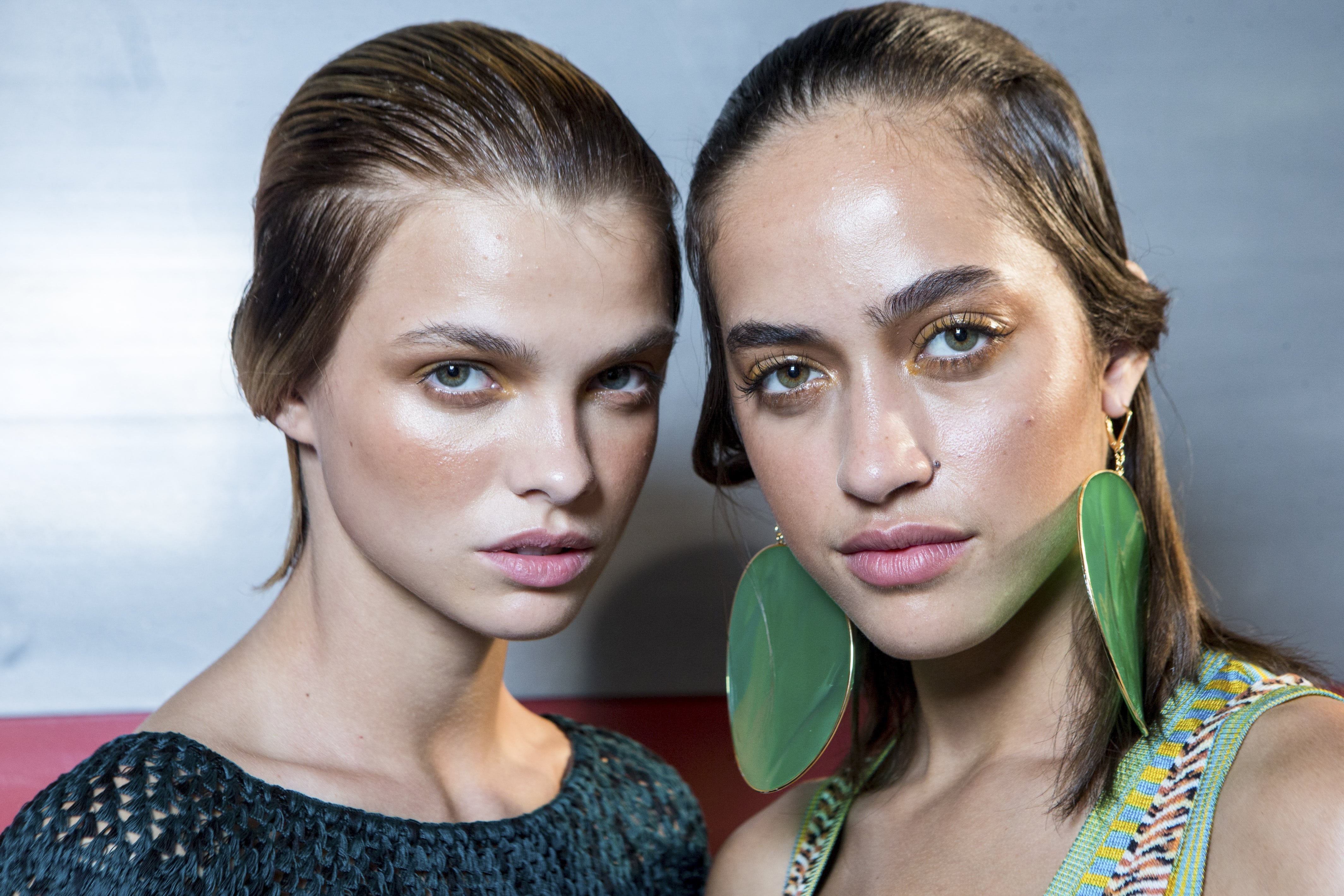 close up shot of models backstage at the Missoni show, with wet look hair and slick partings, wearing holiday clothing