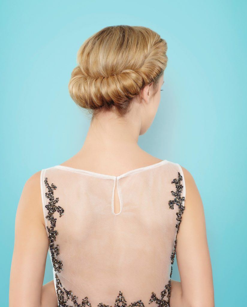 back view final look at blonde model with her hair in a twisted croissant chignon updo