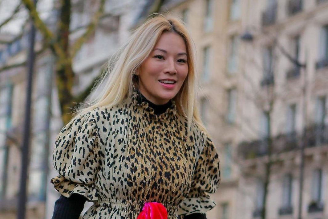 Purple shampoo: Street style photo of an Asian woman with warm blonde hair wearing a leopard print dress with a red tie and red bag