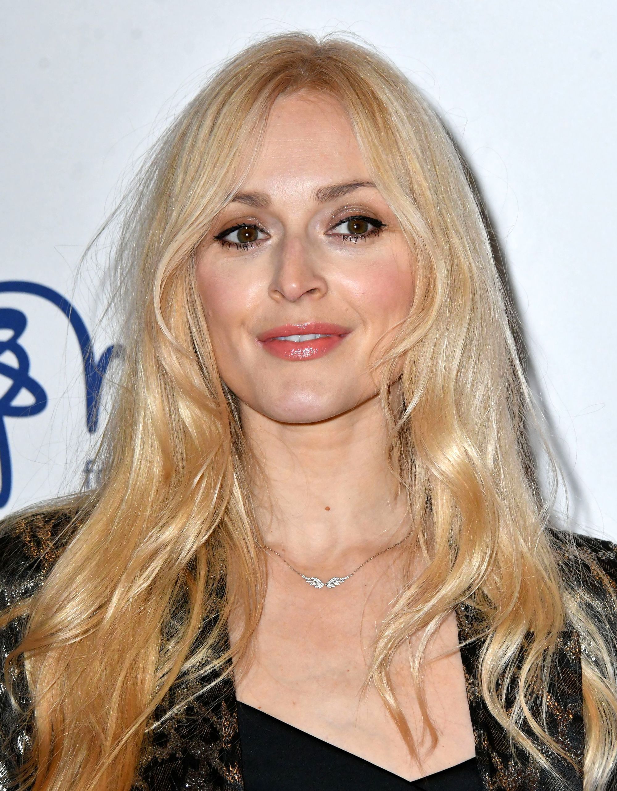 Fearne Cotton with long fine golden blonde hair with face-framing layers, wearing suit jacket on the red carpet