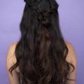 Diwali hairstyles: Back view of a woman with long dark hair wearing a half up half down twist hairstyle