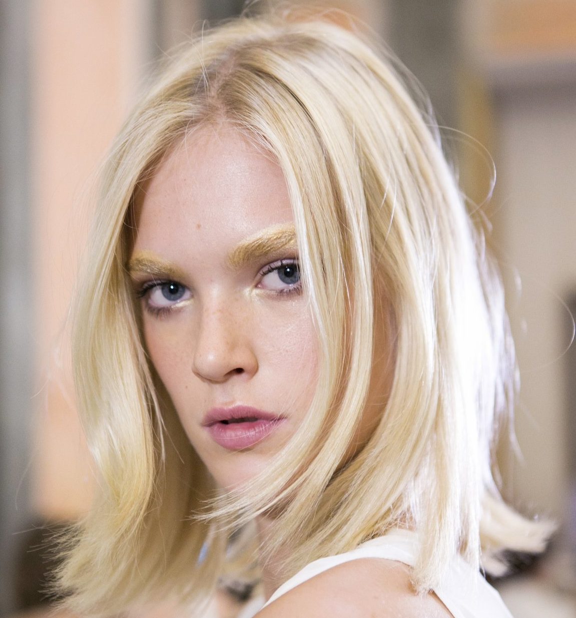 platinum blonde bob with flicked ends and bleached eyebrows