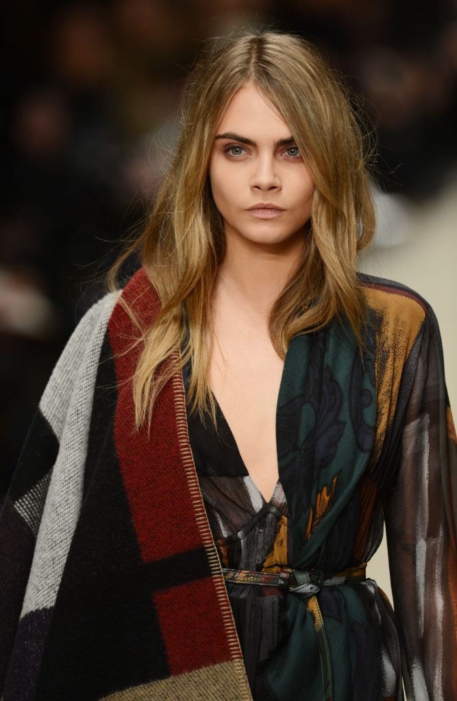 front view image of Cara Delevingne on the runway with blonde brown hair