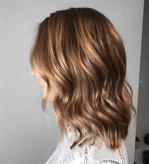 side view image of a woman with chocolate brown hair in waves - blonde brown hair