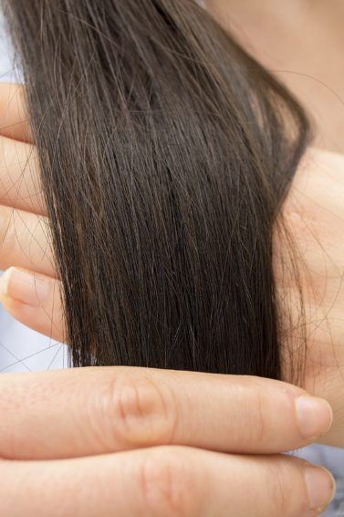 Split end treatment All Things Hair - IMAGE - brown long hair being examined