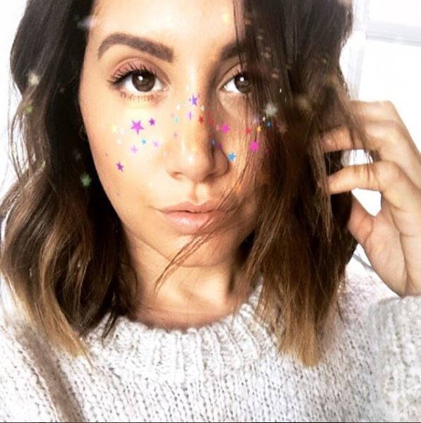 selfie of ashley tisdale with balayage brown long wavy bob and glitter on her face