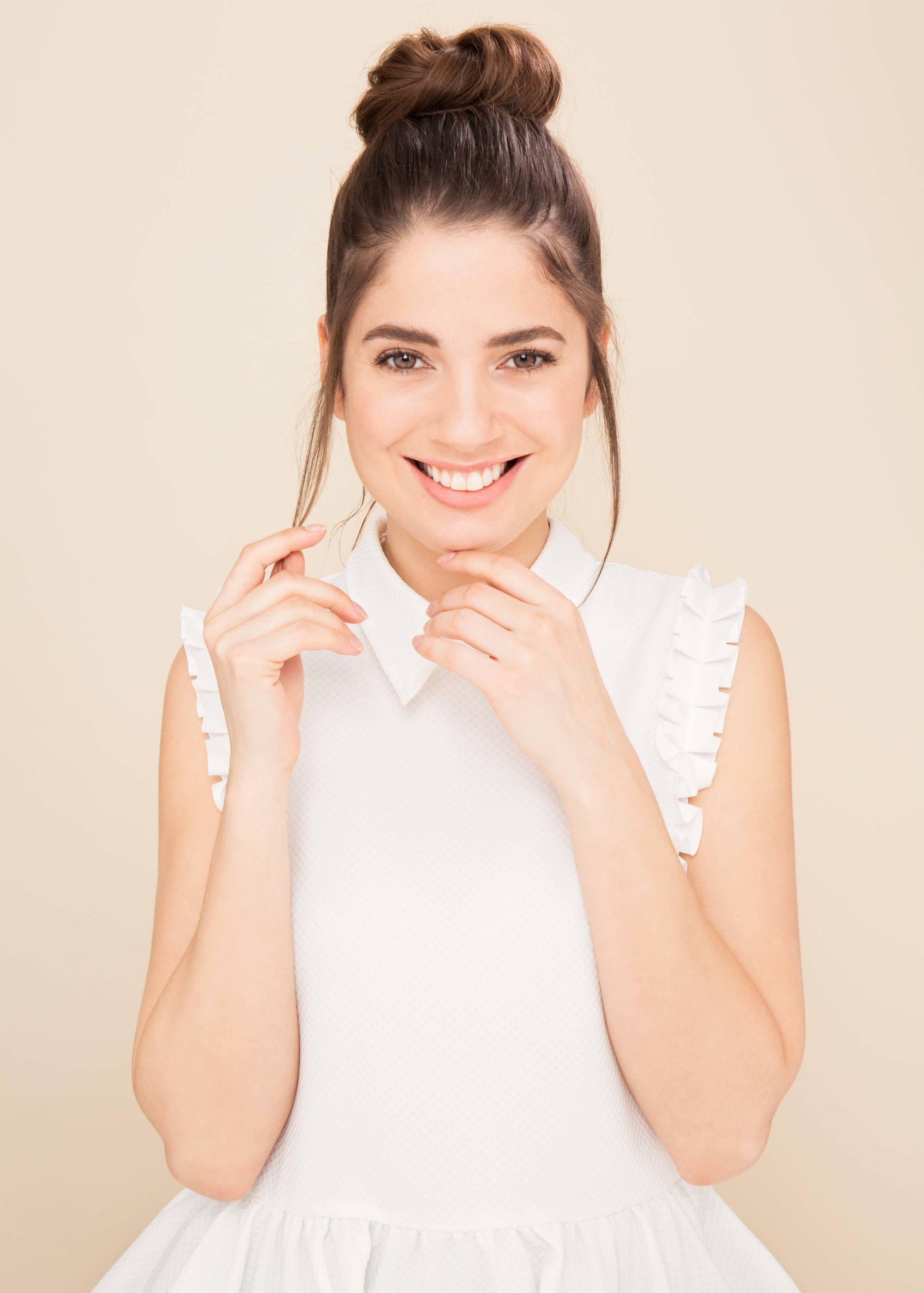 Updos for long hair: model with long brown hair styled into a casual topknot