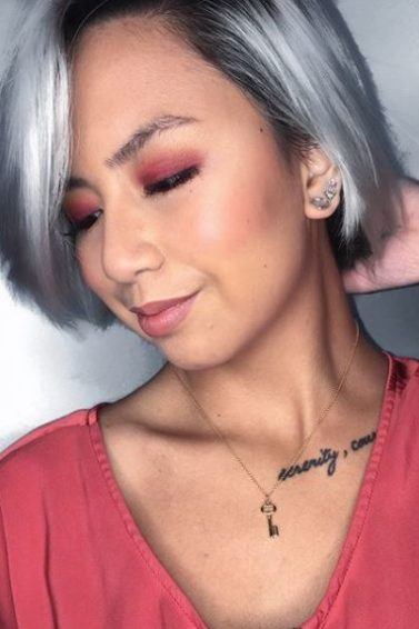 Instagram pic of @erikaseas touching her grey short hair and looking down