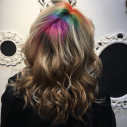woman with wavy brown hair and rainbow roots