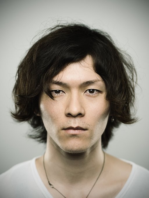 front shot of an asian man with a medium length messy shag haircut