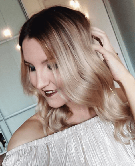 woman looking to the side with long blonde hair and waves with tinsel hair