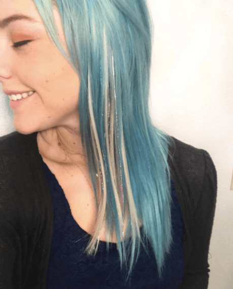 side view of a woman's face with blue hair and tinsel streaks