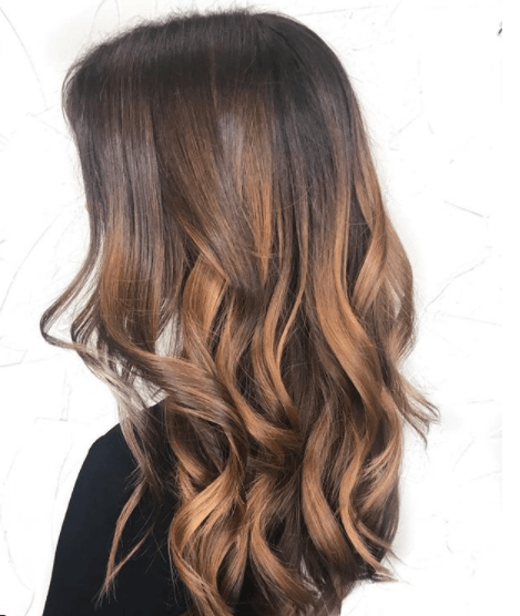 side view image of a woman with long wavy dark brown and auburn hair colour
