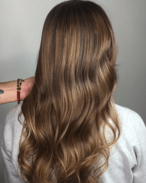 back view of a womans long brown wavy hair