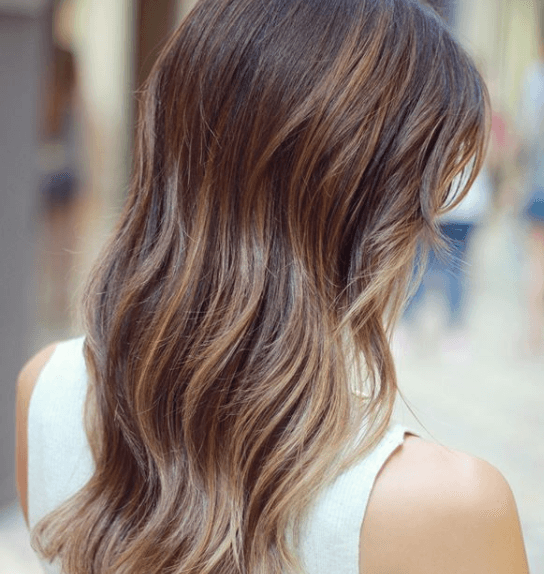 side view image of a woman with long wavy brown - tiger eye hair