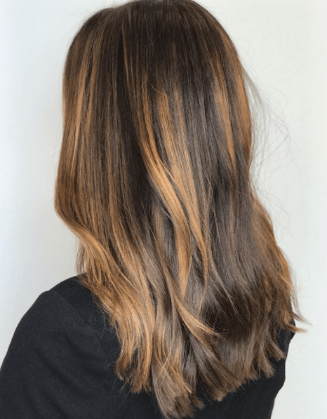 back view of a woman's hair worn down and loose with balayage
