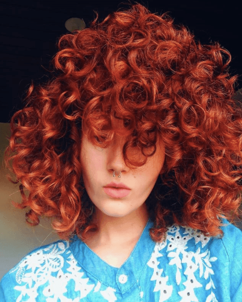 front view image of a woman with red curly hair