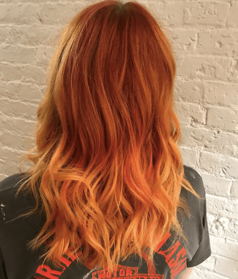 back view of a woman with bright red hair colour and orange ends