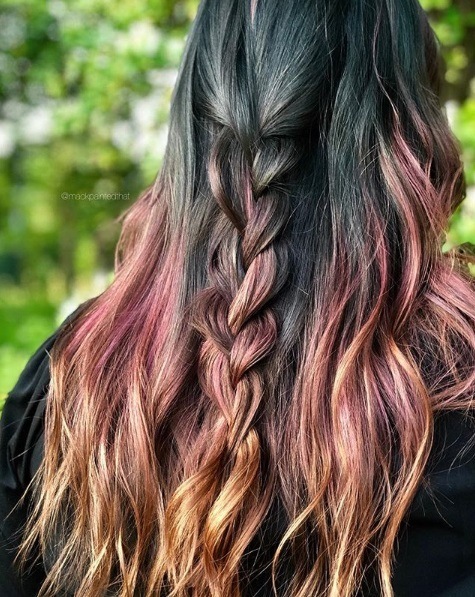back view of a woman with long wavy hair in a teal pink and orange colour melt with a half-up half-down braid