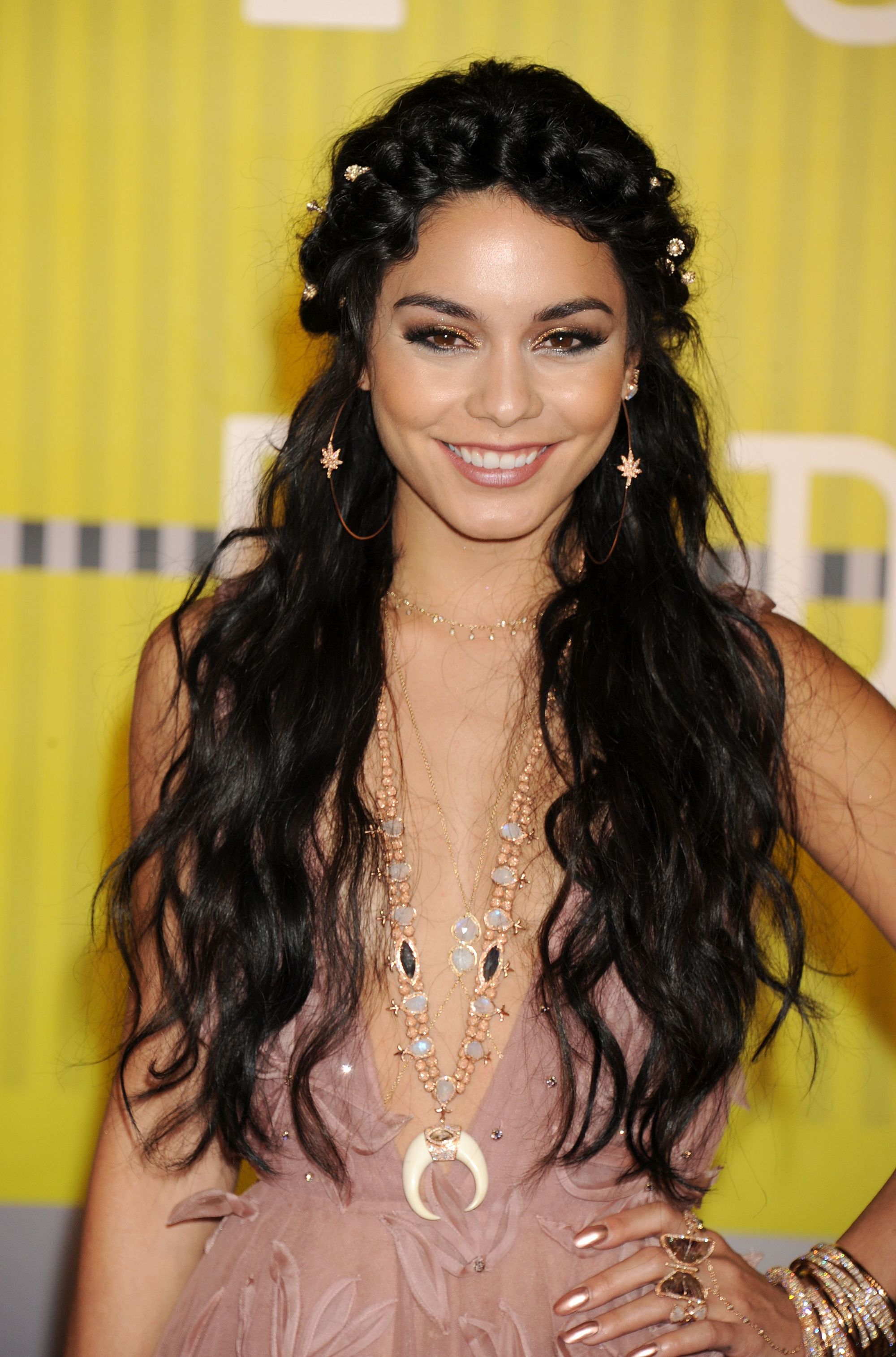 Curly hair hairstyles: Vanessa Hudgens with long dark brown wavy hair styled in a half-up halo braid on red carpet