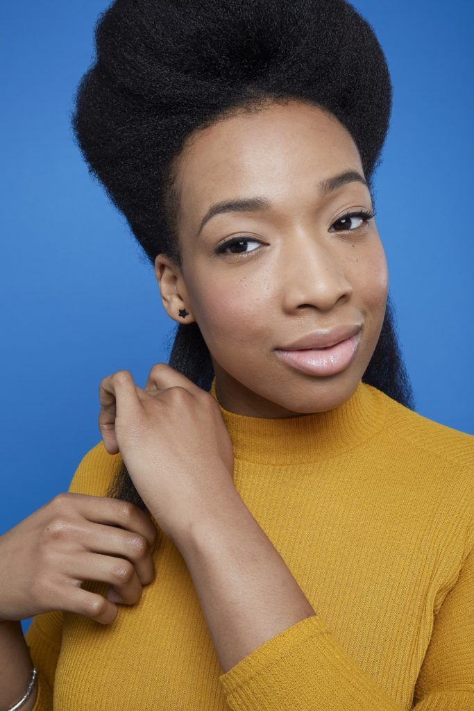 Woman with black afro hair applying cream to hair before flexi rods