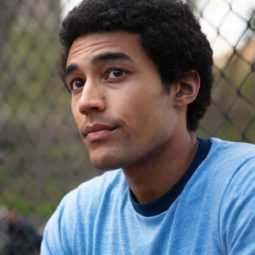 man playing the character of Barack Obama in the Barry Netflix's film with a small afro hairstyle wearing a blue t-shirt