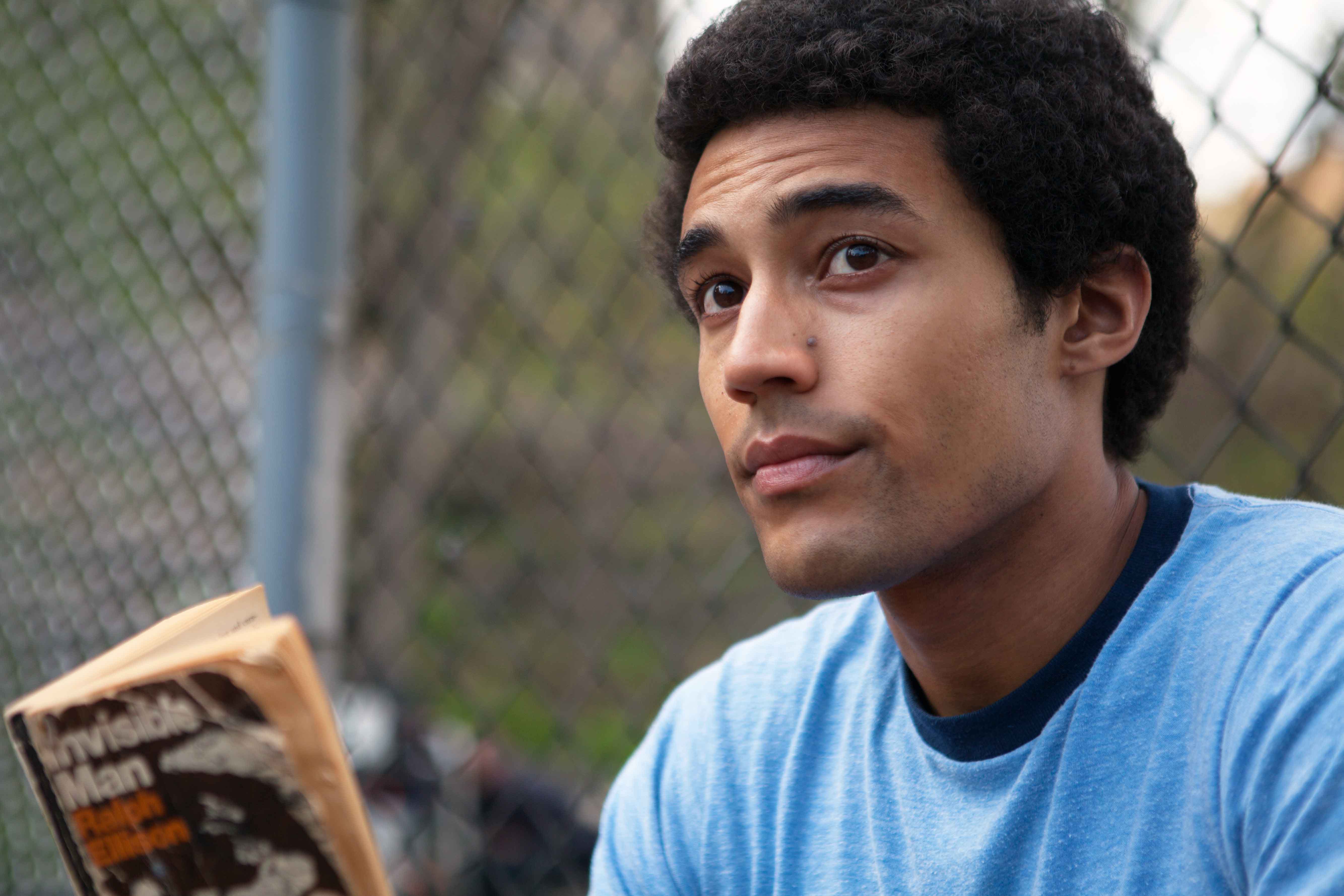 man playing the character of Barack Obama in the Barry Netflix's film with a small afro hairstyle wearing a blue t-shirt