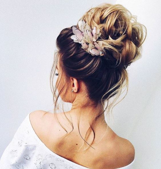 back side view of long blonde hair in high bun with butterfly hair accessories