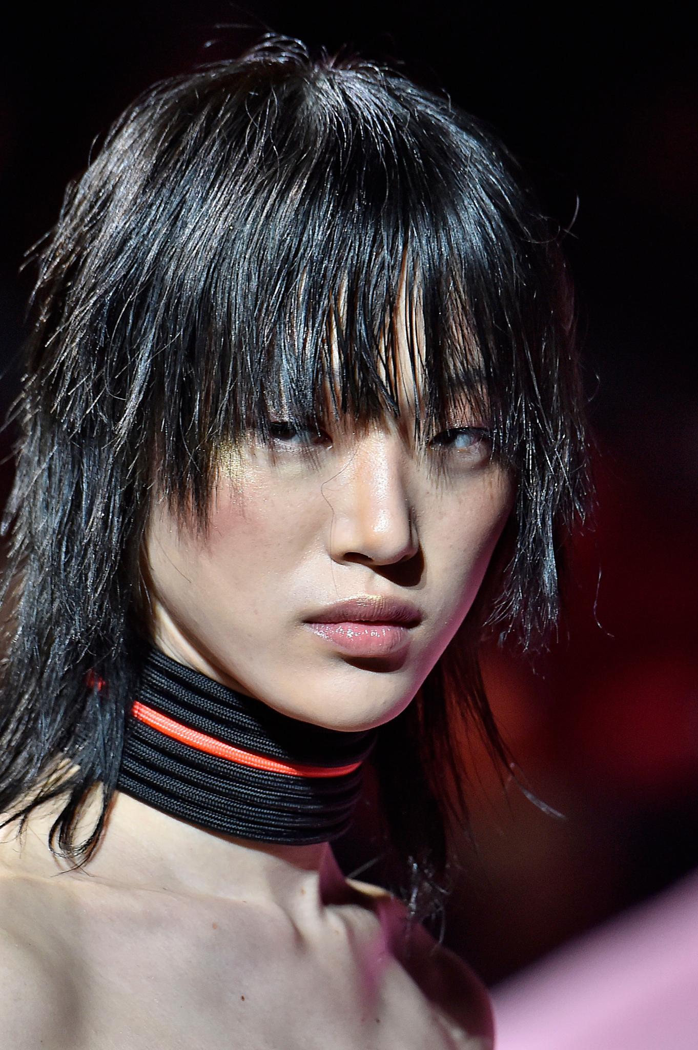 Retro hairstyles: Close up shot of a woman with a medium choppy shag haircut, wearing a choker on the Fenty Puma runway