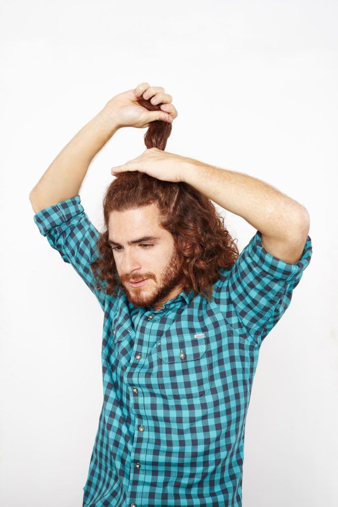 man sectioning curly hair in half