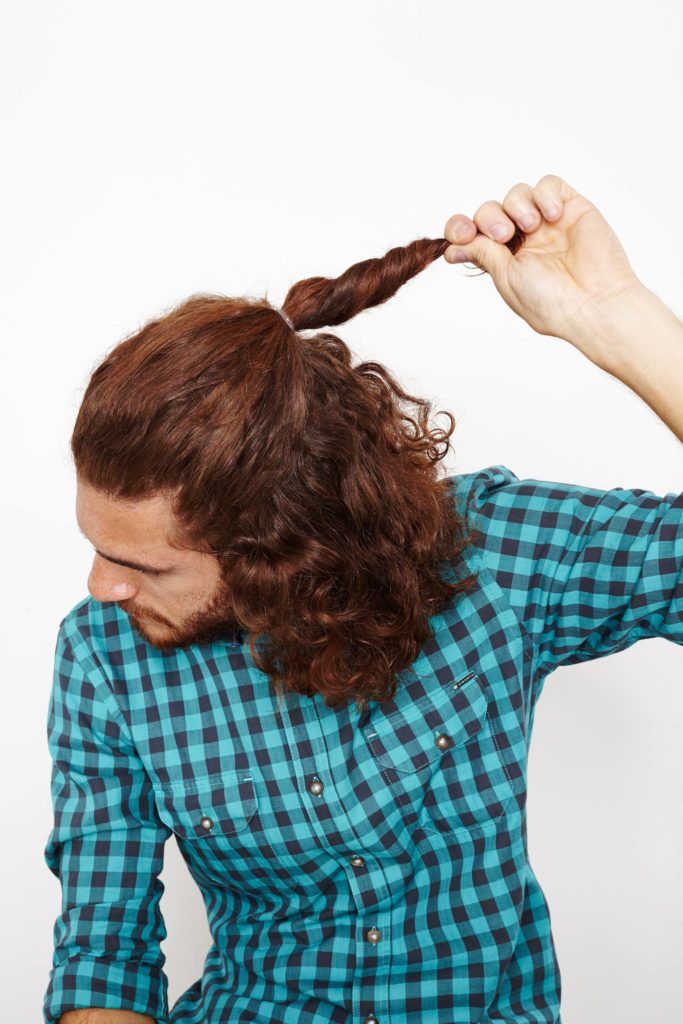 half up half down ponytail on man with curly hair