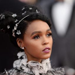 close up shot of janelle with space bun afro hairstyle that has accessories in it, wearing ruffled dress