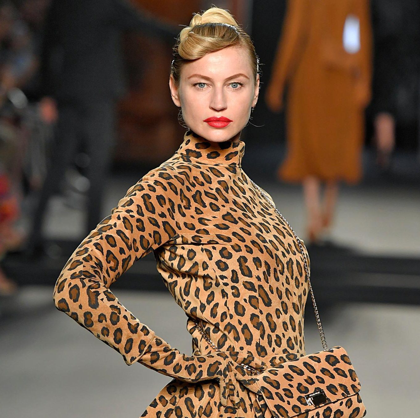 Retro hairstyles: Close up shot of a woman with golden blonde short hair styled into a retro updo walking on the Julien Fournie runway