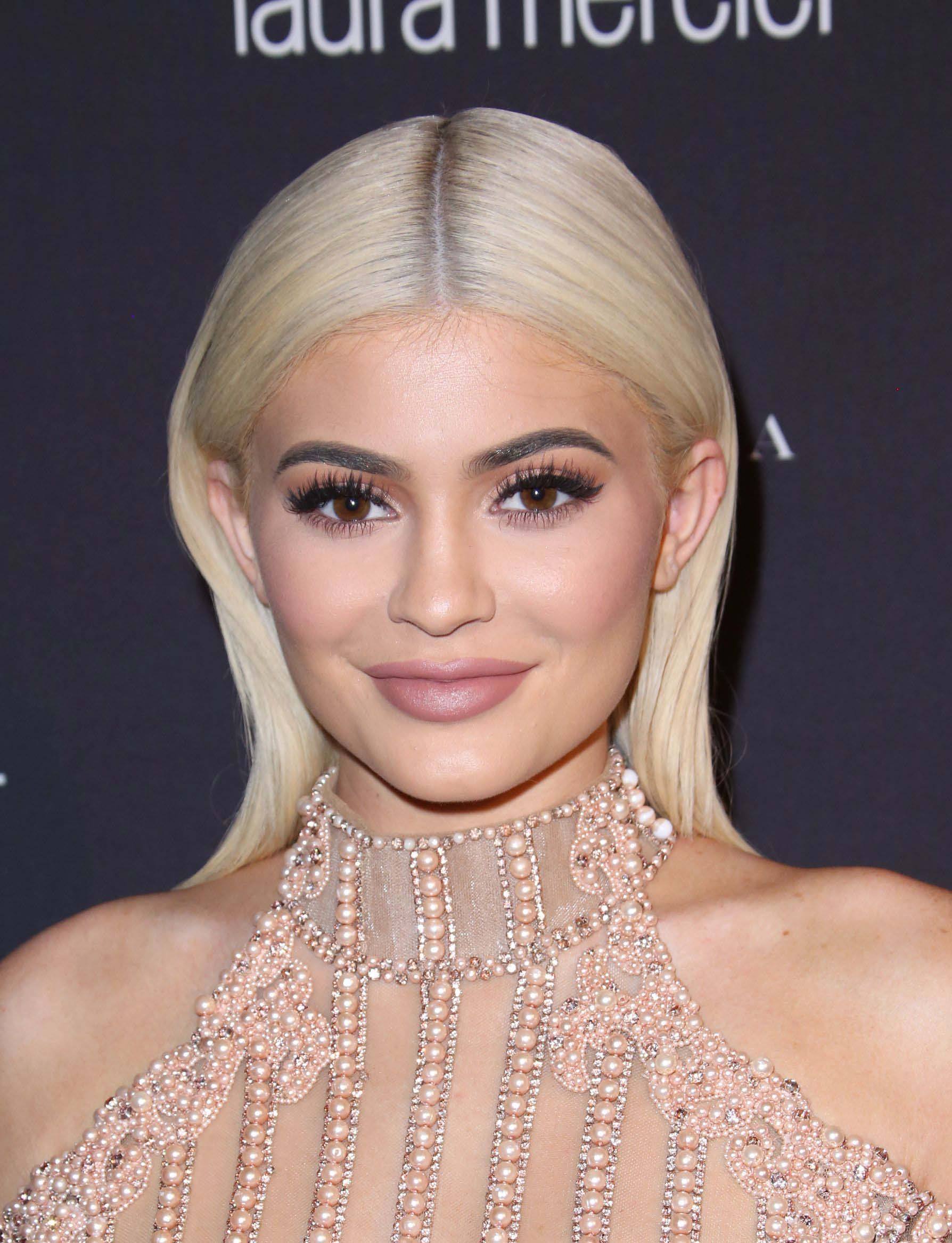 close up shot of kylie jenner with platinum blonde hair, wearing pearly dress on the red carpet