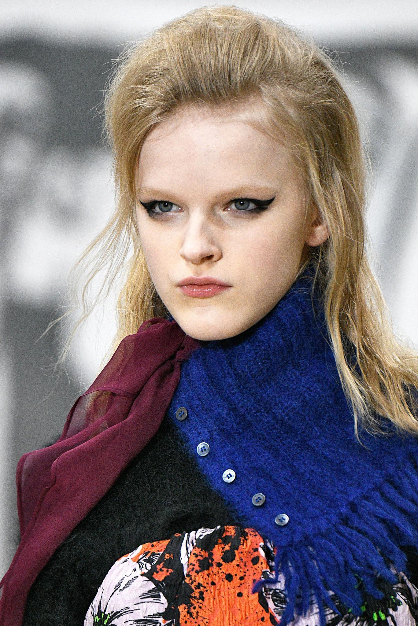 Retro hairstyles: Close up shot of a woman with natural blonde hair styled into a swept back quiff hairstyle on the runway