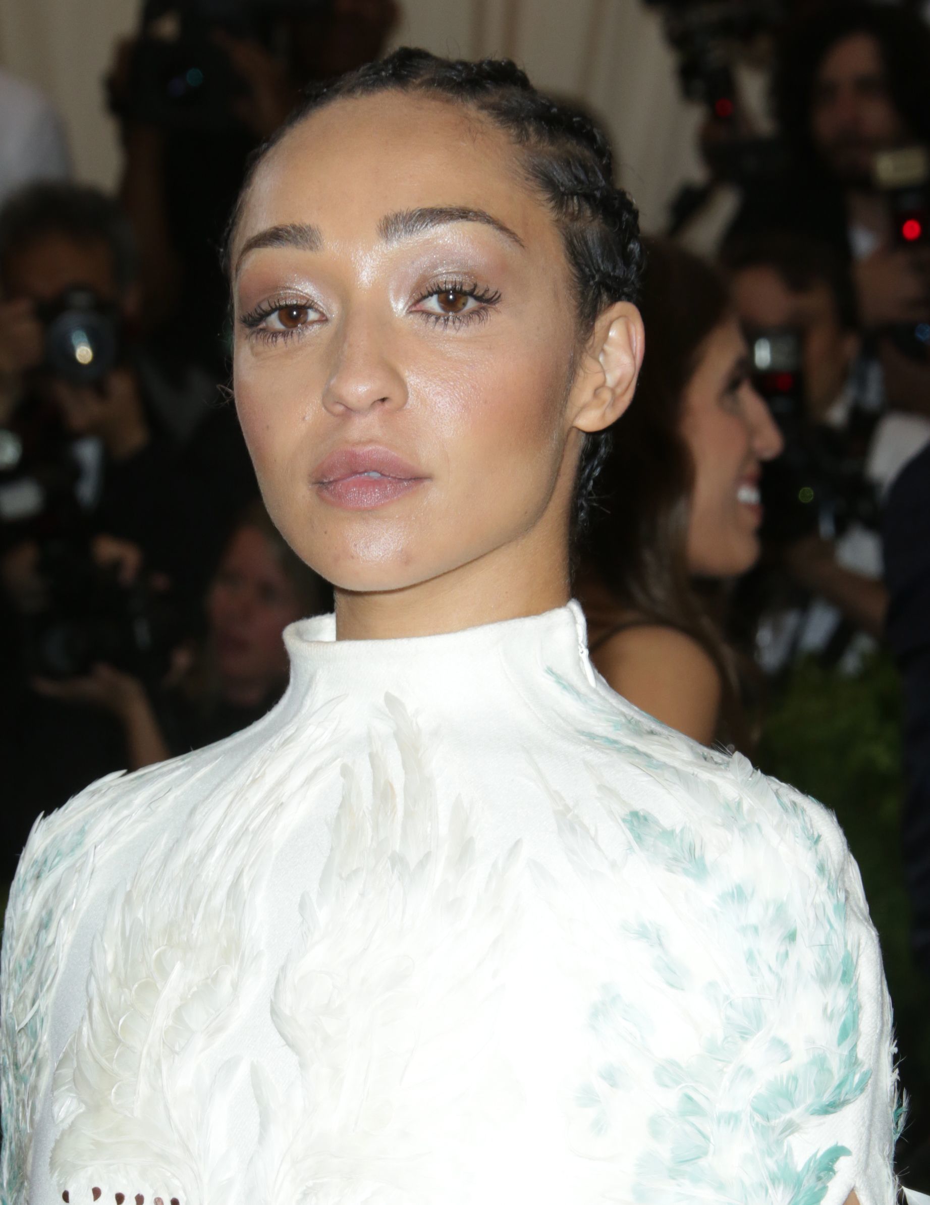 close up shot of ruth negga with cornrows, wearing a white dress on the met gala red carpet