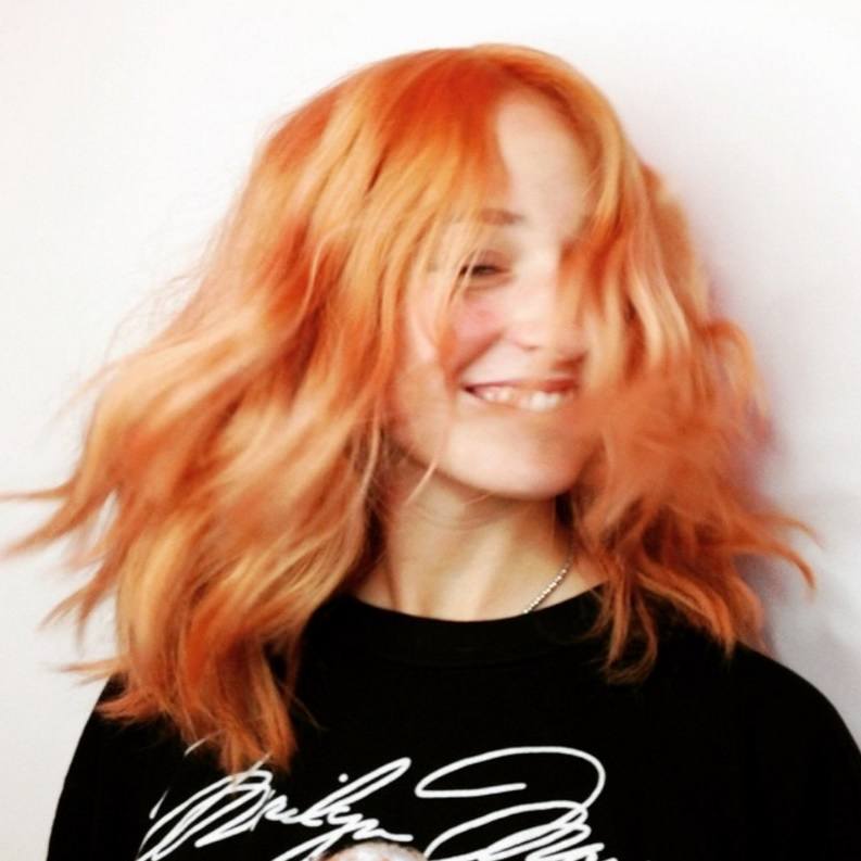 woman with bright orange hair colour worn in a wavy style