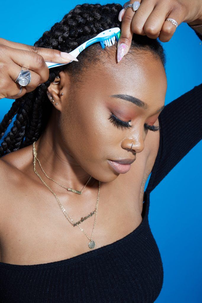 a black woman hair brushing her baby hair