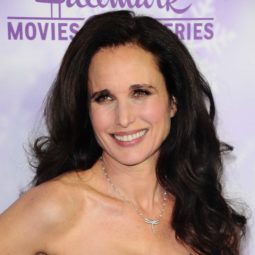 Andie MacDowell on the red carpet wearing a black dress with her wavy dark brown hair styled in a blowout