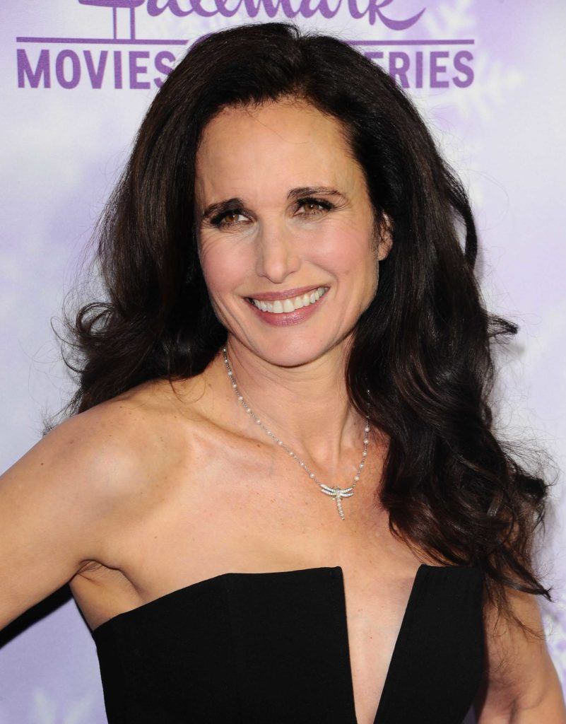 Andie MacDowell on the red carpet wearing a black dress with her wavy dark brown hair styled in a blowout