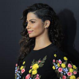 Camila Alves with a side braided curly hairstyle wearing a floral dress