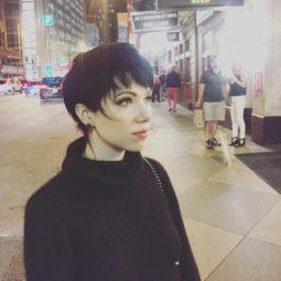 Carly Rae Jepsen with a brown long pixie shag haircut wearing all black