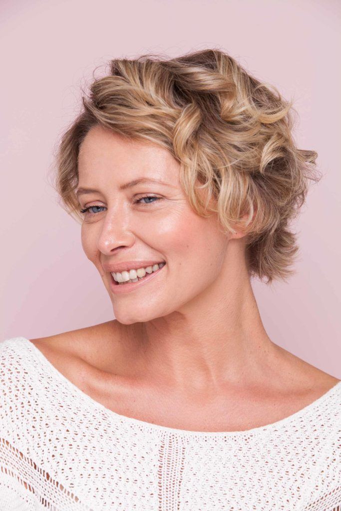 curling very short hair with blonde-haired woman
