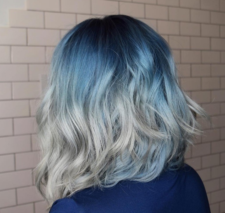back view of woman with shoulder length denim ombre hair colour finished with waves