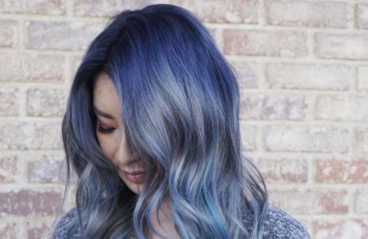 An Instagrammer with wavy denim blue ombre hair