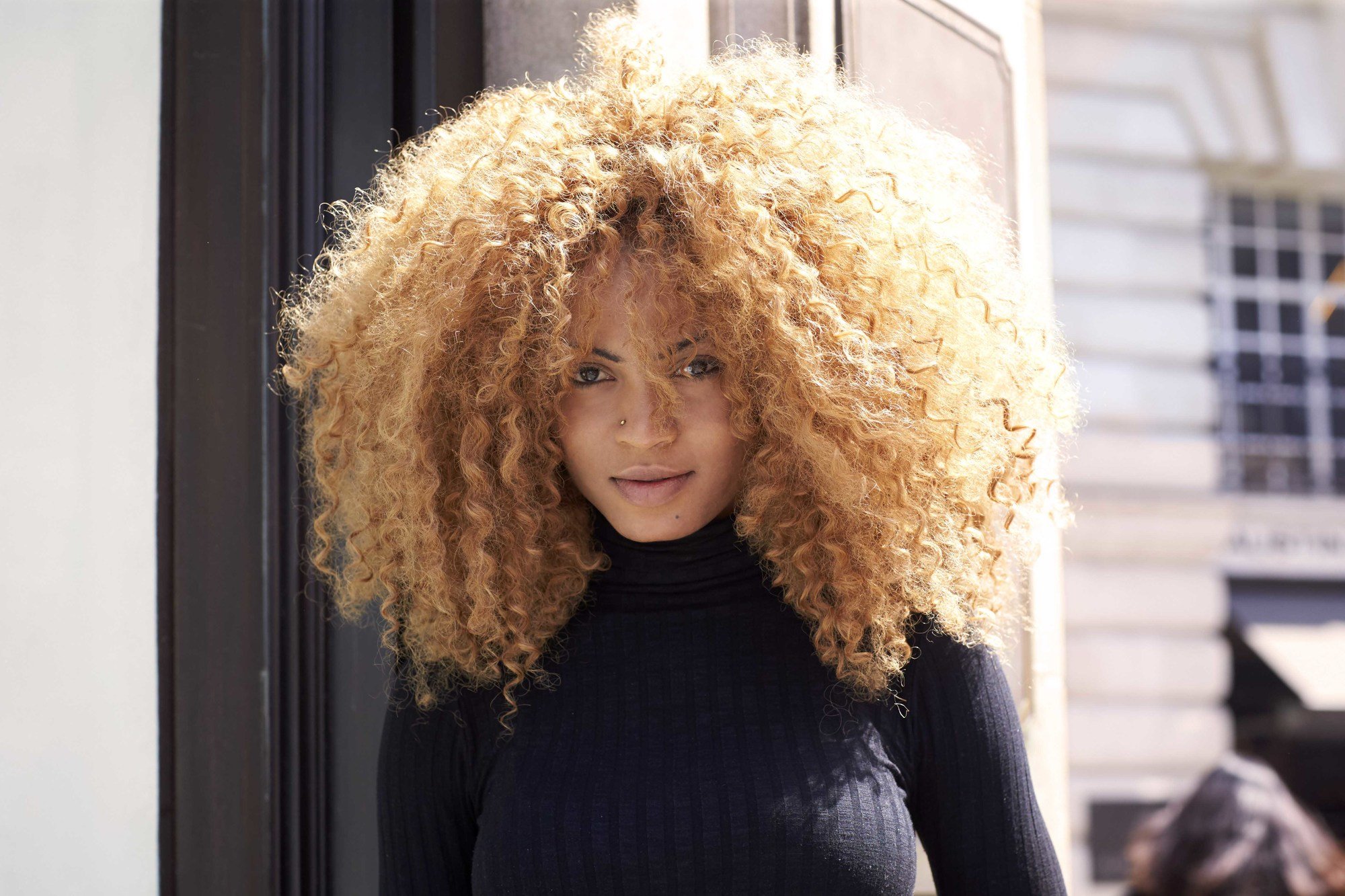 natural haired young woman with a big curly, copper coloured afro