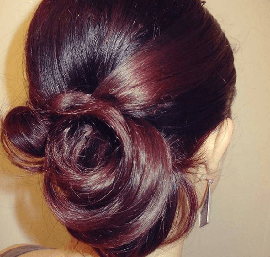 red highlights on black hair in a bun hairstyle