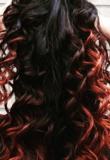 a red curly hair of a woman playing with her hair