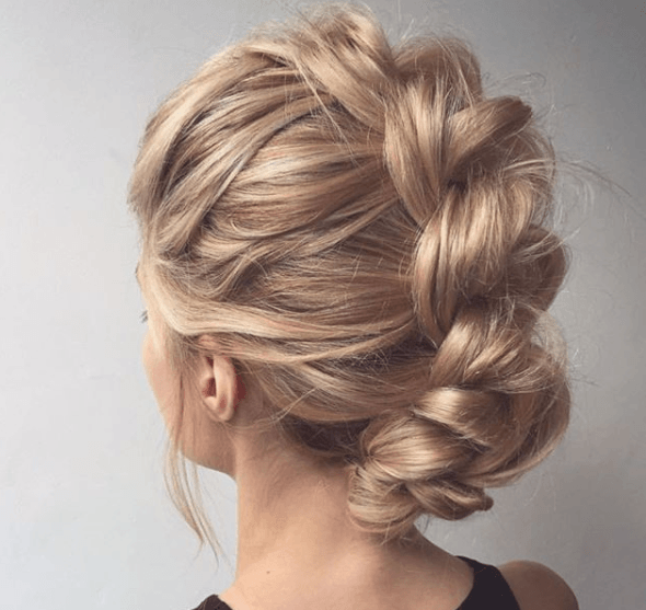 back view of a woman's blonde hair in a braided up 'do - prom hairstyles for long hair