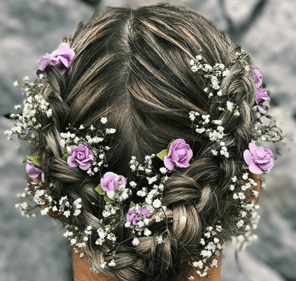 back view of a woman with braids and flowers in her hair - prom hairstyles for long hair
